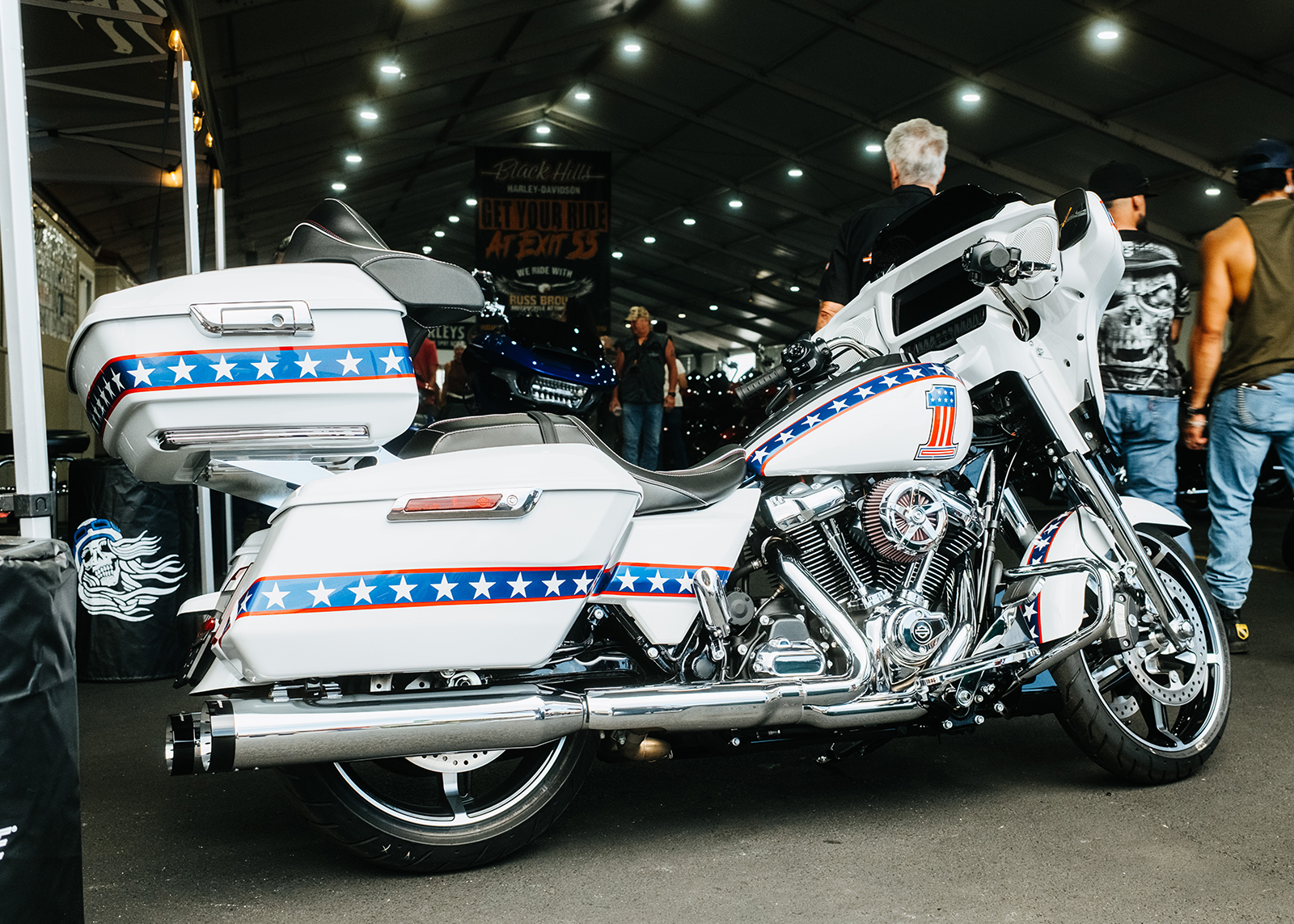 Custom Harley-Davidson touring bike with patriotic red, white, and blue star graphics on display indoors.