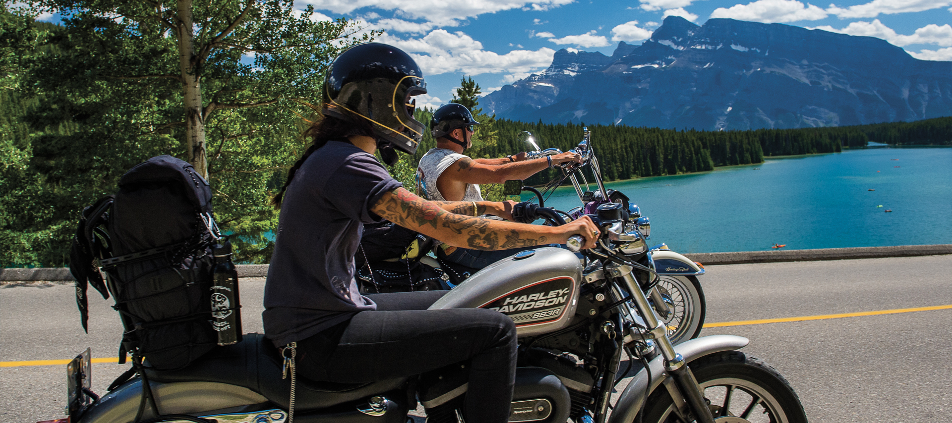 Side view of man and woman riding their bikes near the water
