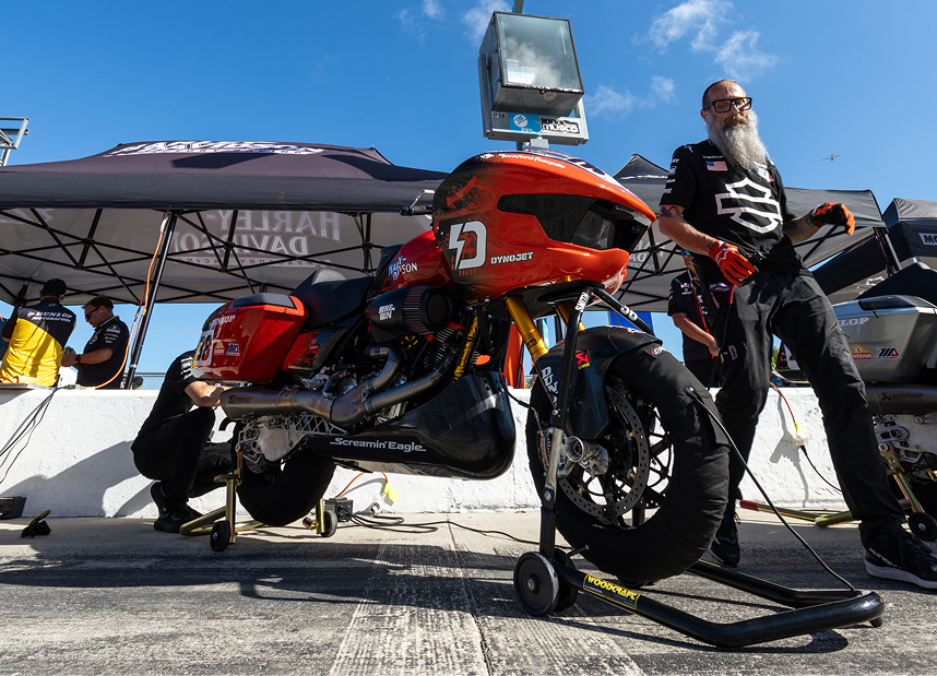 Bradley Smith’s motorcycle sits on paddock stands while being worked on by the Harley-Davidson Race Team crew
