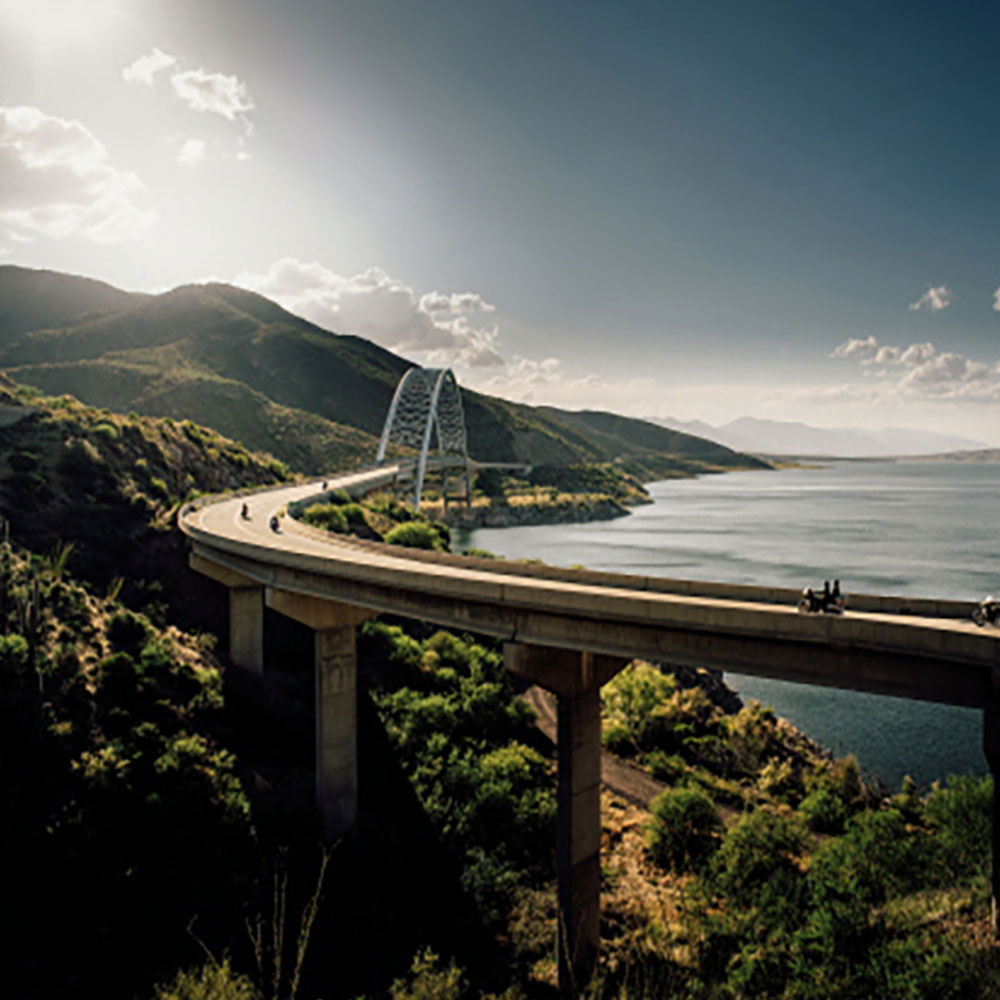 Bikes riding on a bridge by the coast