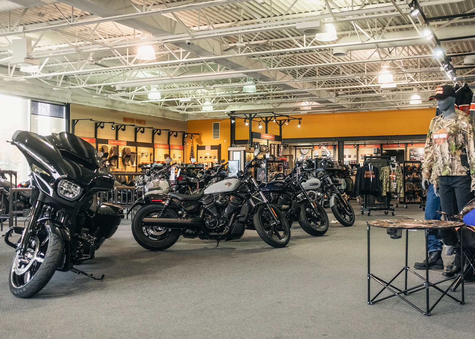 The interior of Woodstock Harley-Davidson showing motorcycles lined up for sale along with riding gear and apparel.