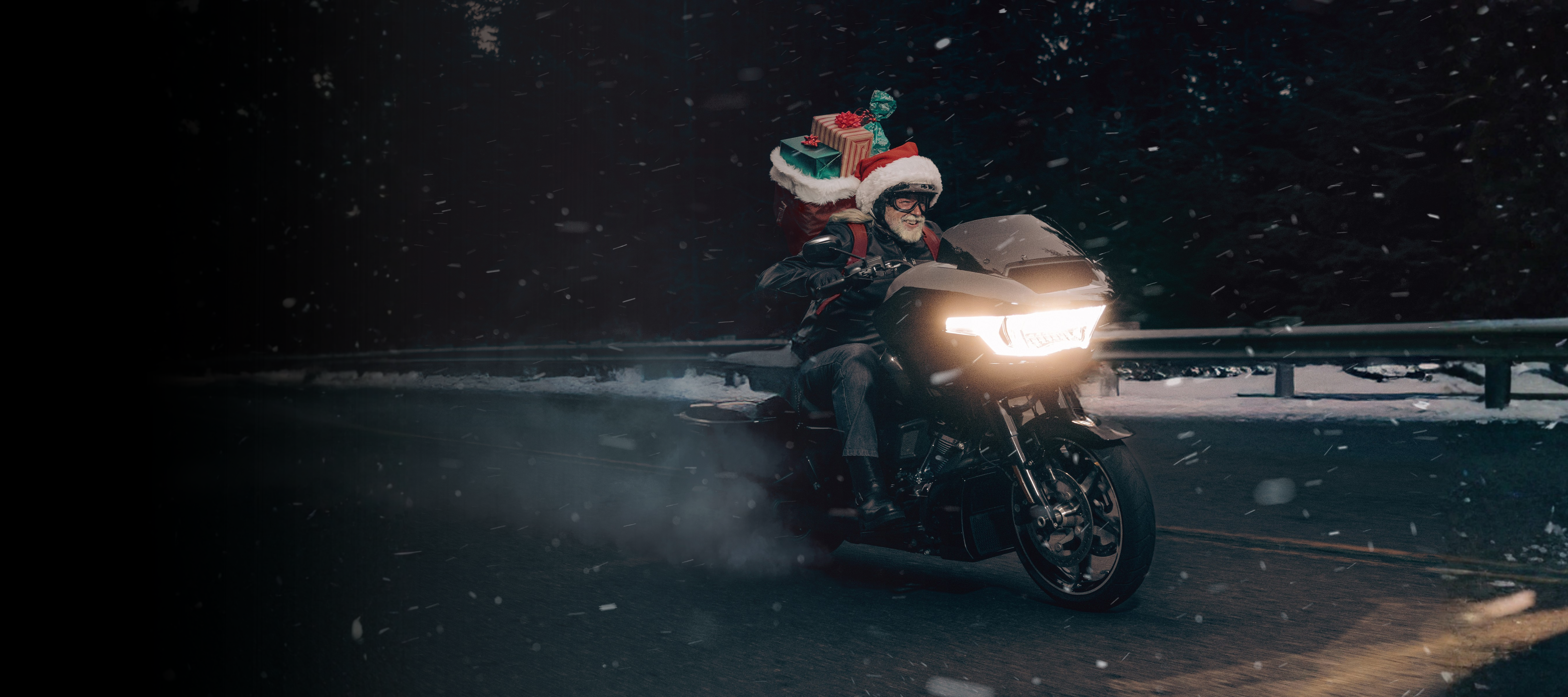 Santa está montando una bicicleta con regalos.