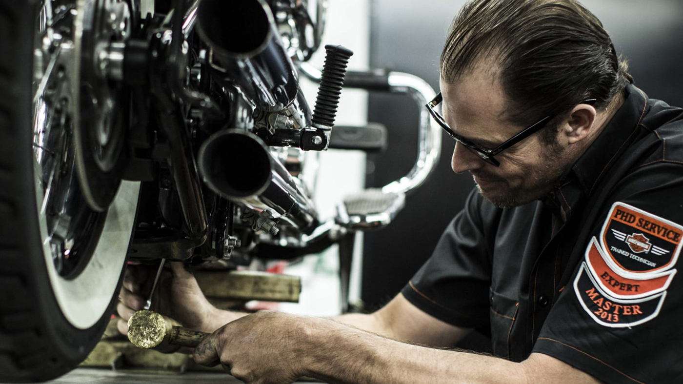 man fixing motorcycle