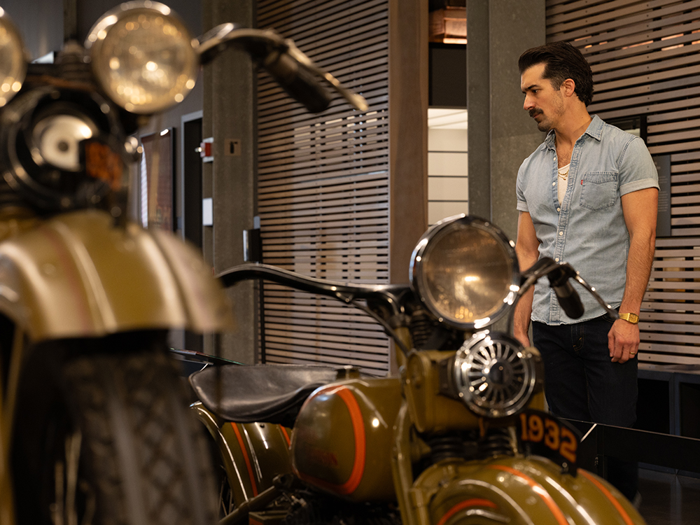 Visitor examining historic Harley-Davidson motorcycles in museum gallery