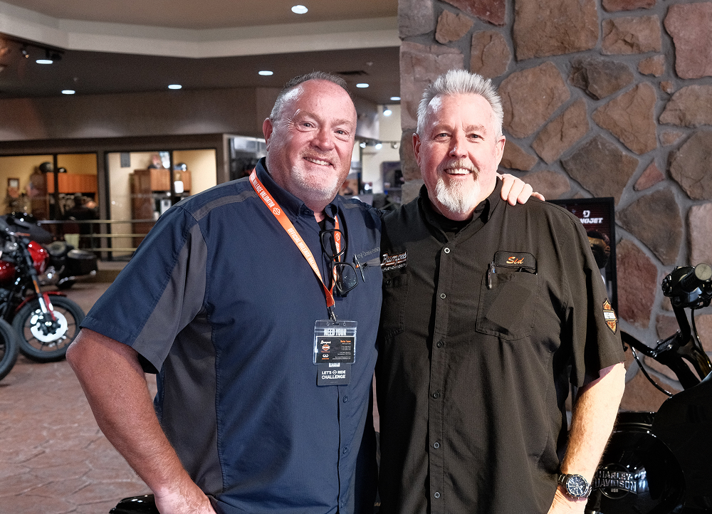 Two Bumpus Harley-Davidson dealership staff members standing together inside the showroom