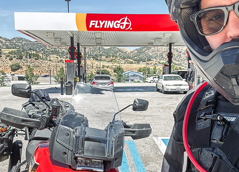 Selfie at gas station with Red H-D Pan America motorcycle at pump under Flying J canopy on sunny day