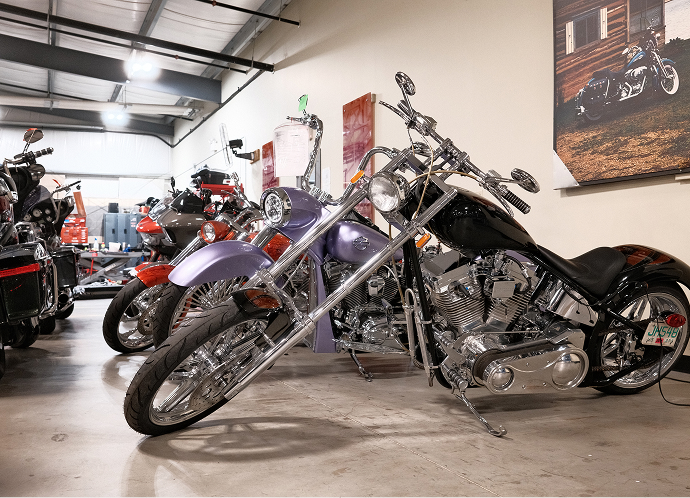 Row of Harley‑Davidson motorcycles displayed inside a showroom, featuring chrome details and polished concrete floors
