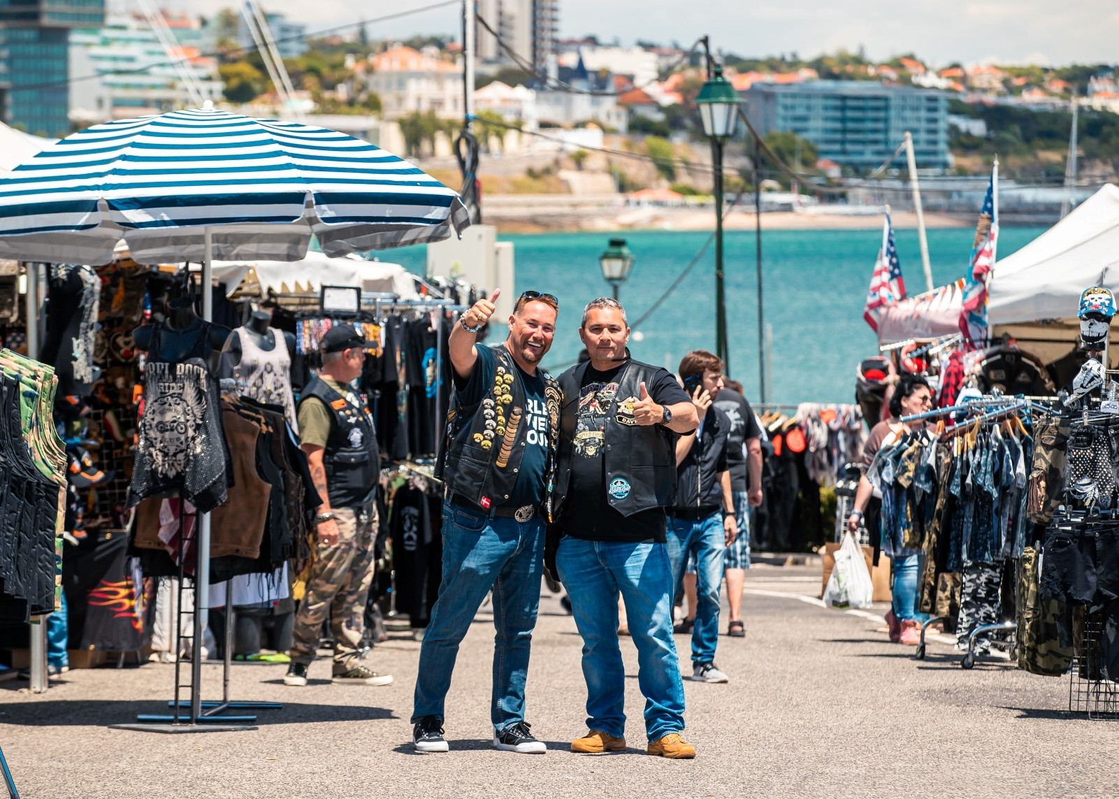 Two men smiling and giving a thumbs-up at a shopping village in Cascais