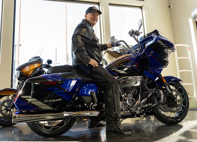 Black & Orange Tier winner Jeff Guynes sits on his new 2025 CVO Road Glide inside Durango Harley-Davidson