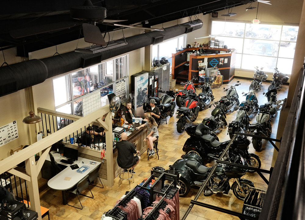 Overhead view of a Harley-Davidson showroom featuring motorcycles, sales desks, and customers