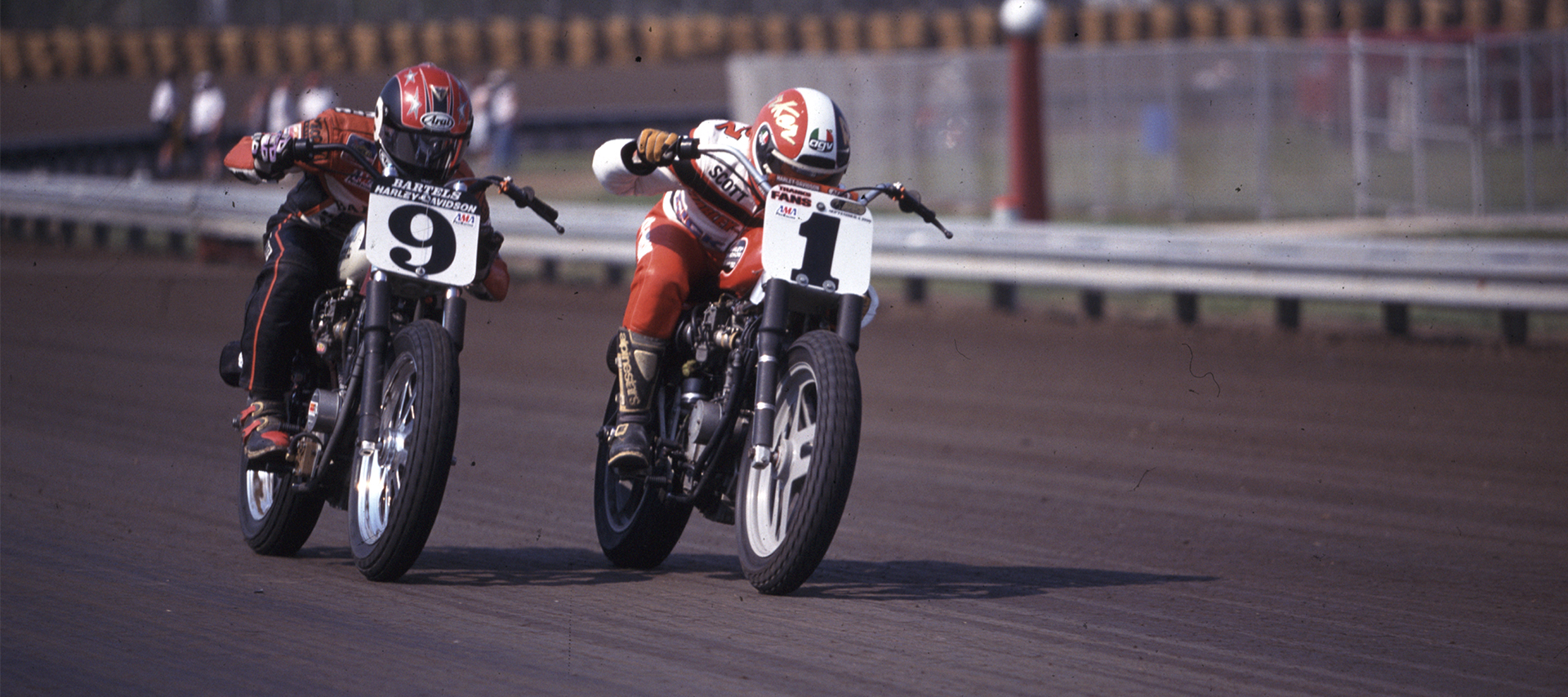 Two racers battle for the lead on a round track 