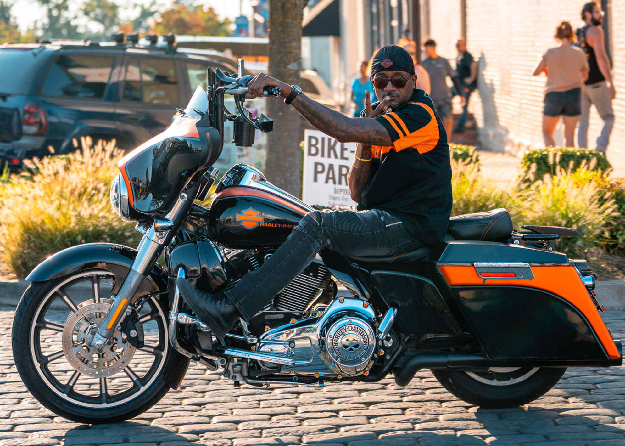 A man on a Street Glide holds up a peace sign