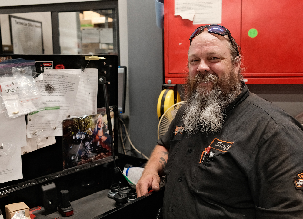 Service technician standing beside a workbench in dealership service department with tools and equipment
