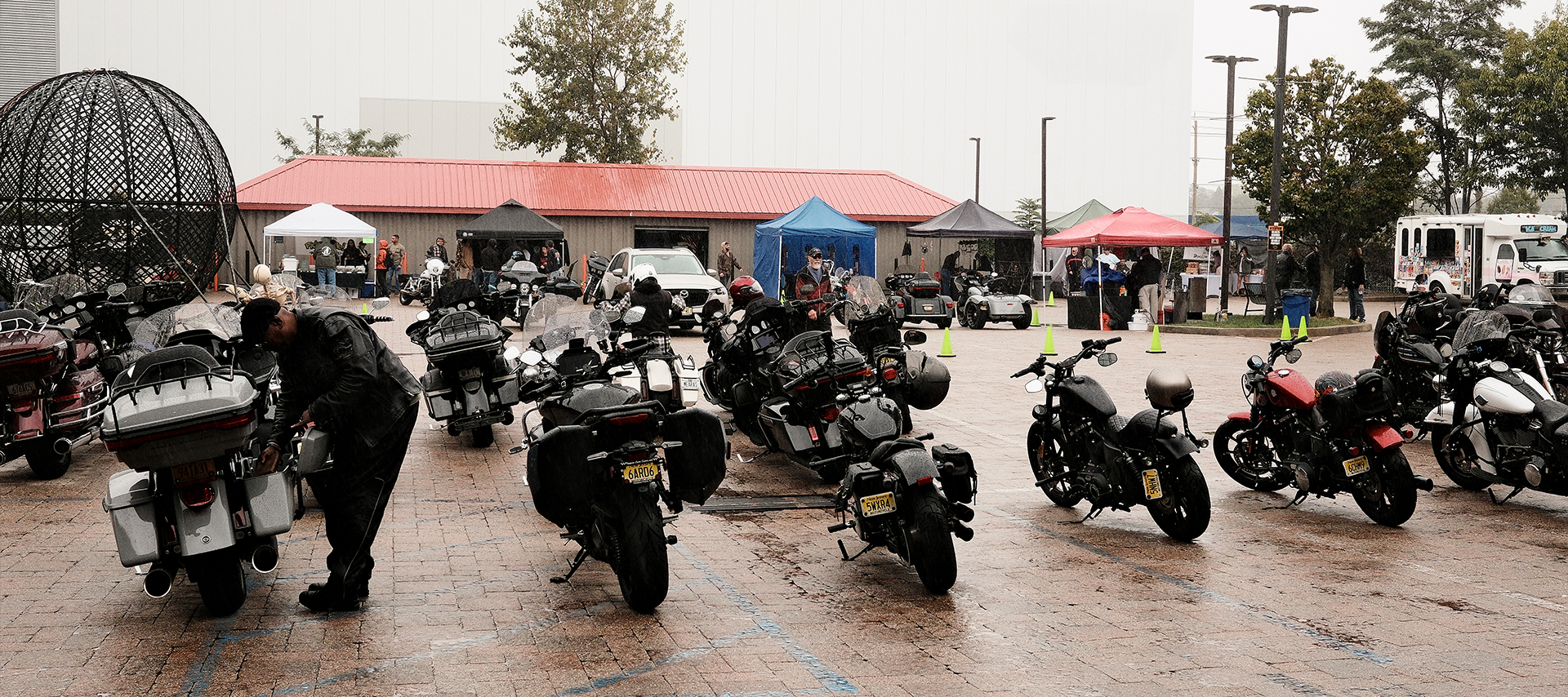 The rainy parking lot full of motorcycles at Bergen Harley-Davidson as their 50th anniversary party wraps up.