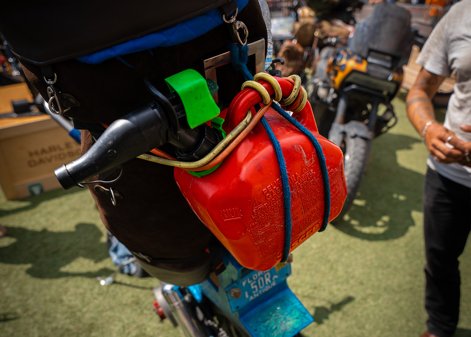A plastic gas can is strapped to the sissy bar of a bike 