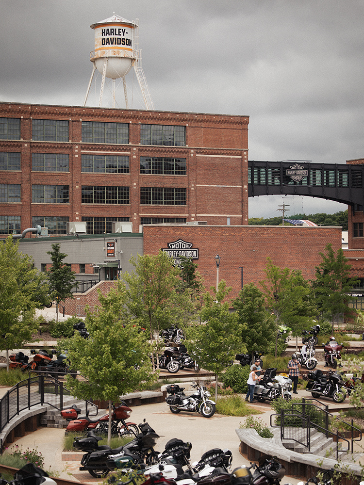 Harley-Davidson building and water tower above a motorcycle-filled plaza