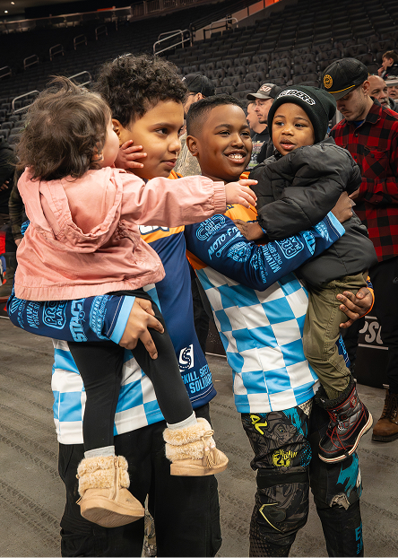 Group of children gathered together on the arena floor during an intermission activity
