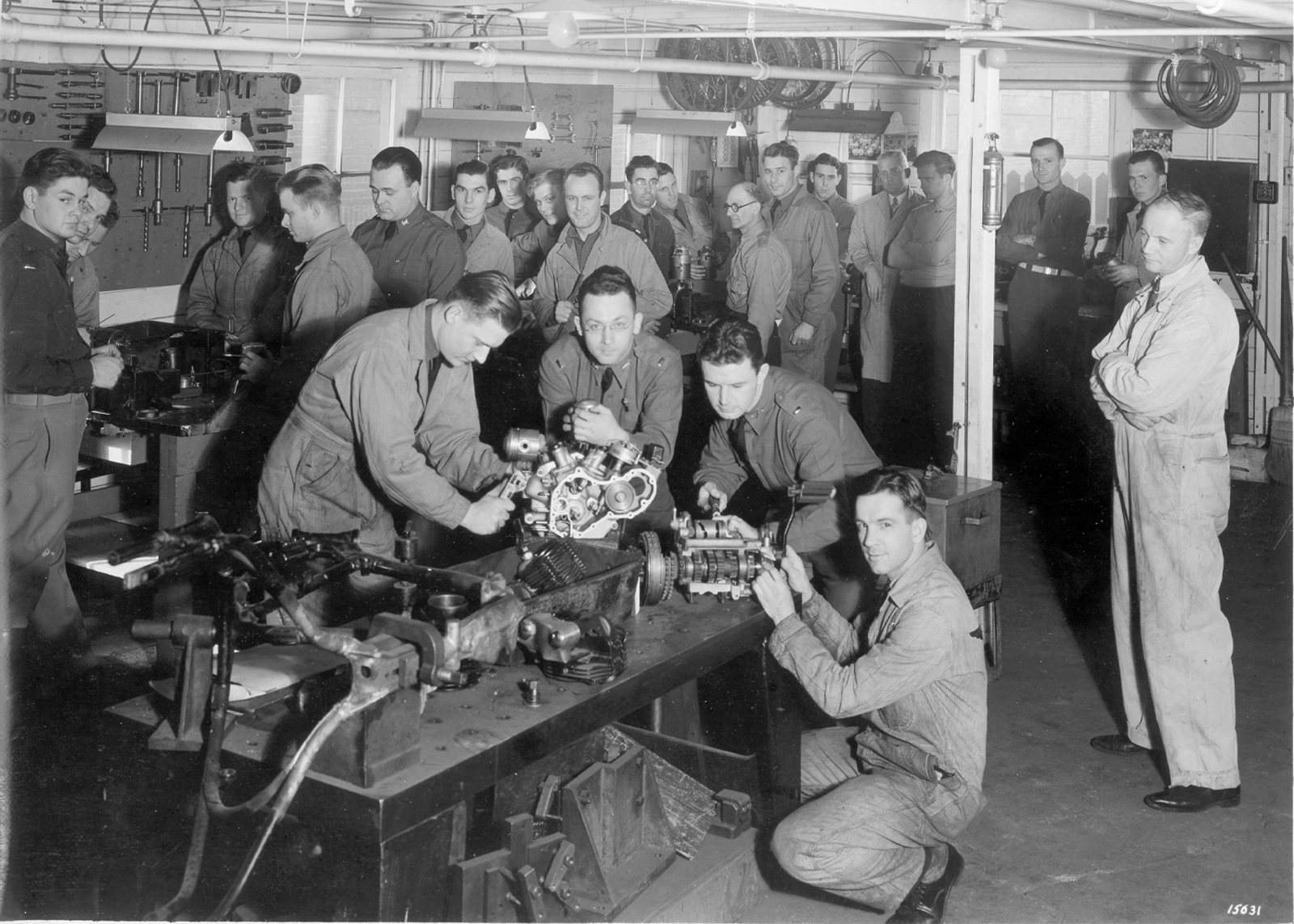 A group of people toil on components in a room
