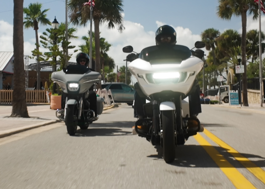 Two motorcycles cruise down main street in Daytona Beach, Florida