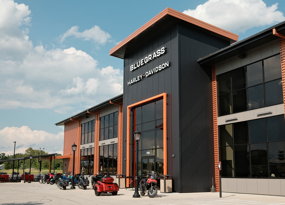 Exterior view of Bluegrass Harley-Davidson dealership with blue skies and motorcycles parked out front