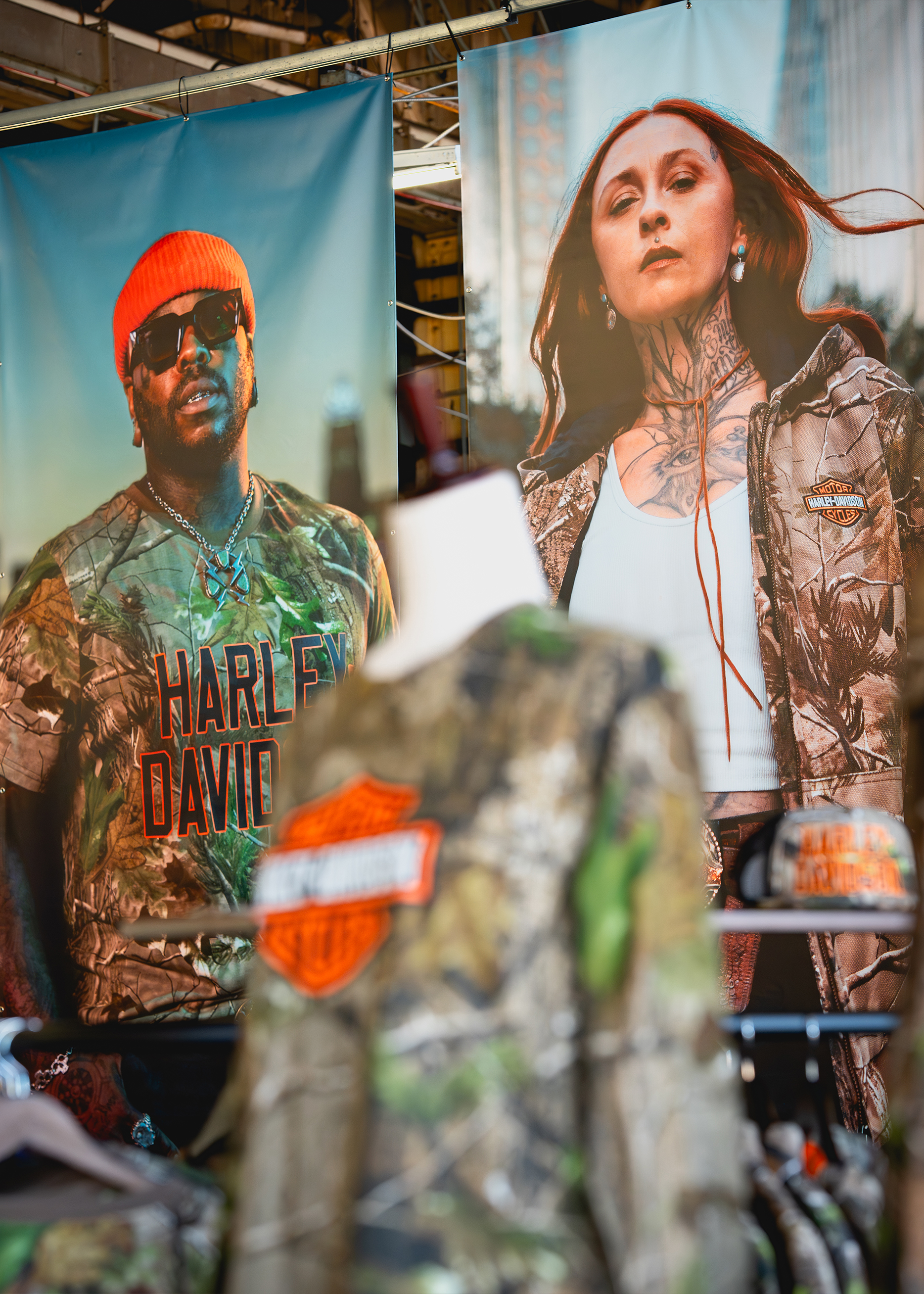 Large posters of camo-clad Harley-Davidson x Realtree models tower over a display of matching apparel.