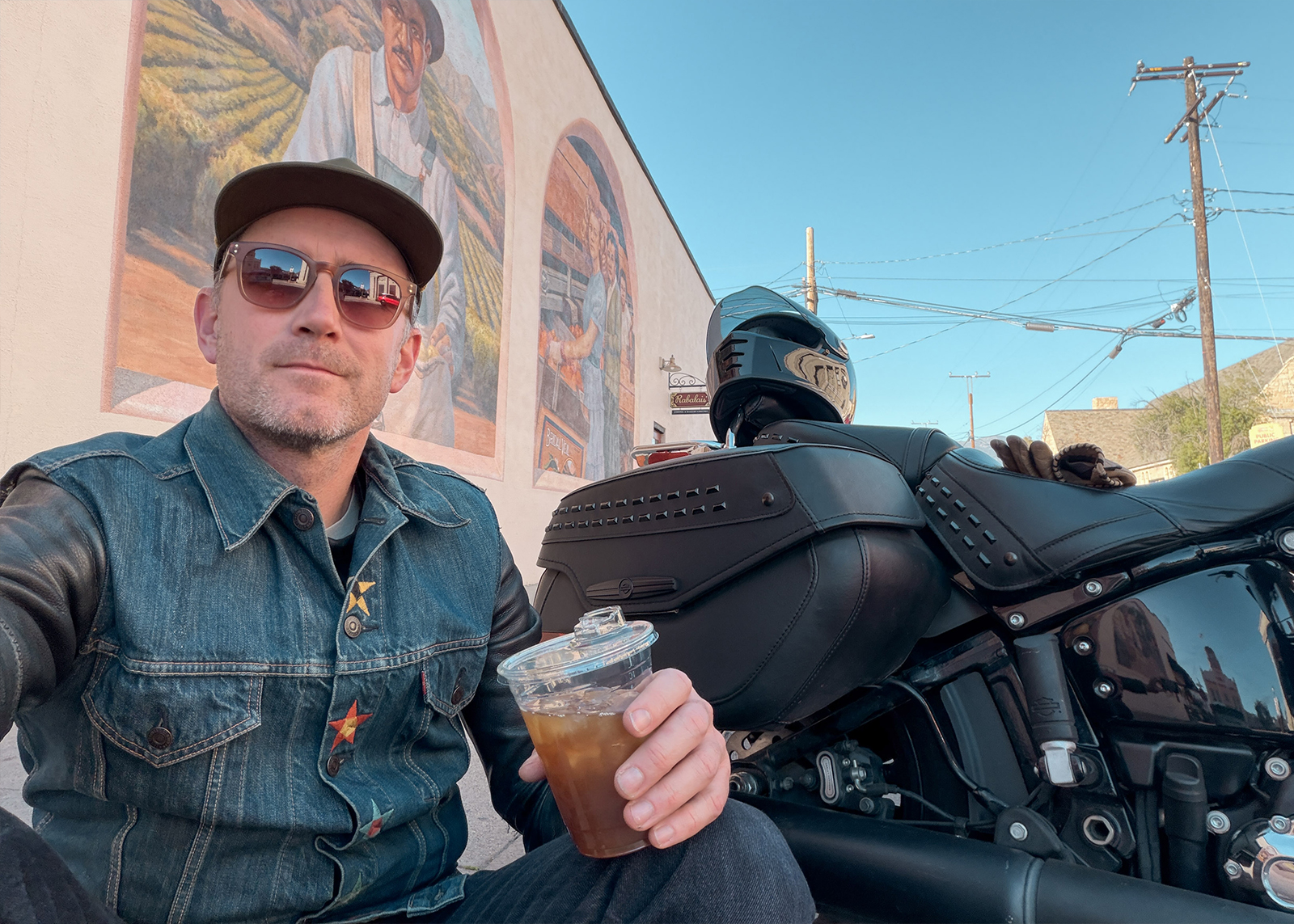 A selfie of the author with cold brew coffee sitting next to his motorcycle outside of Rabalais Bistro