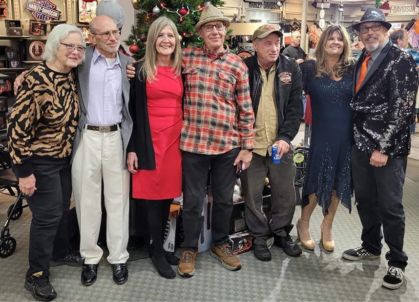 The Kegel family standing indoors near a decorated Christmas tree, dressed in festive and casual clothing