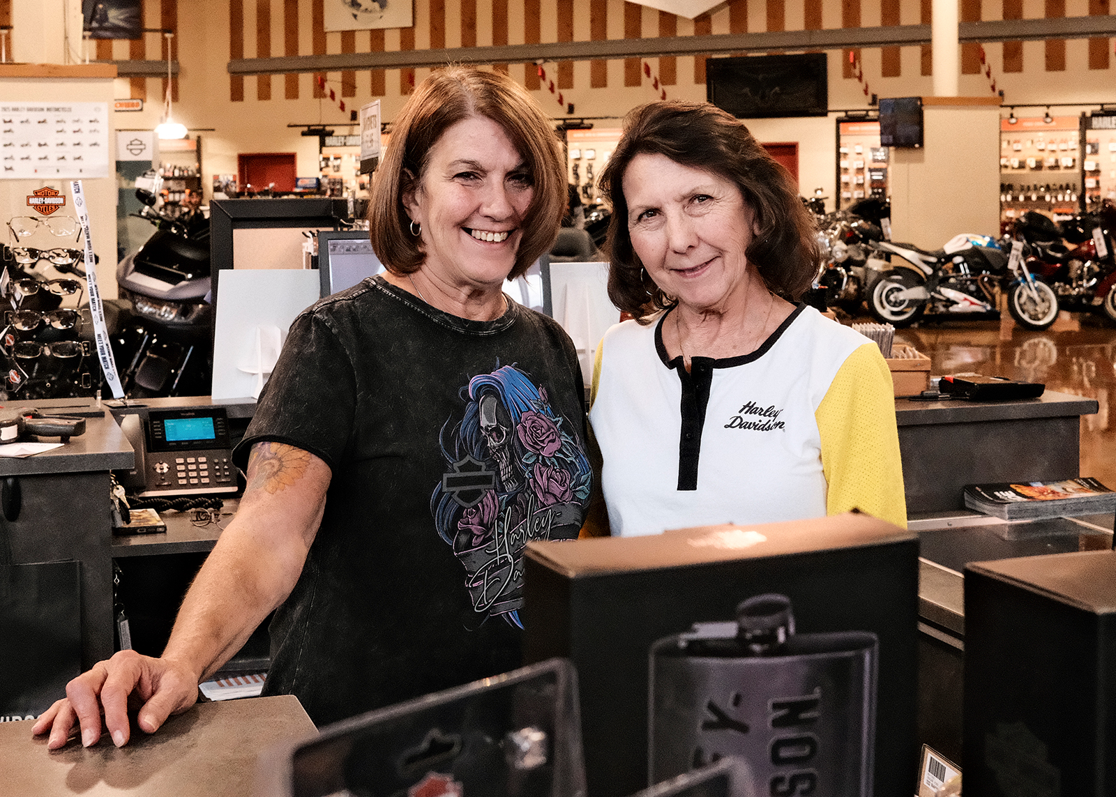 Two staff members pose for a photo near the cash registers at Classic Harley-Davidson.