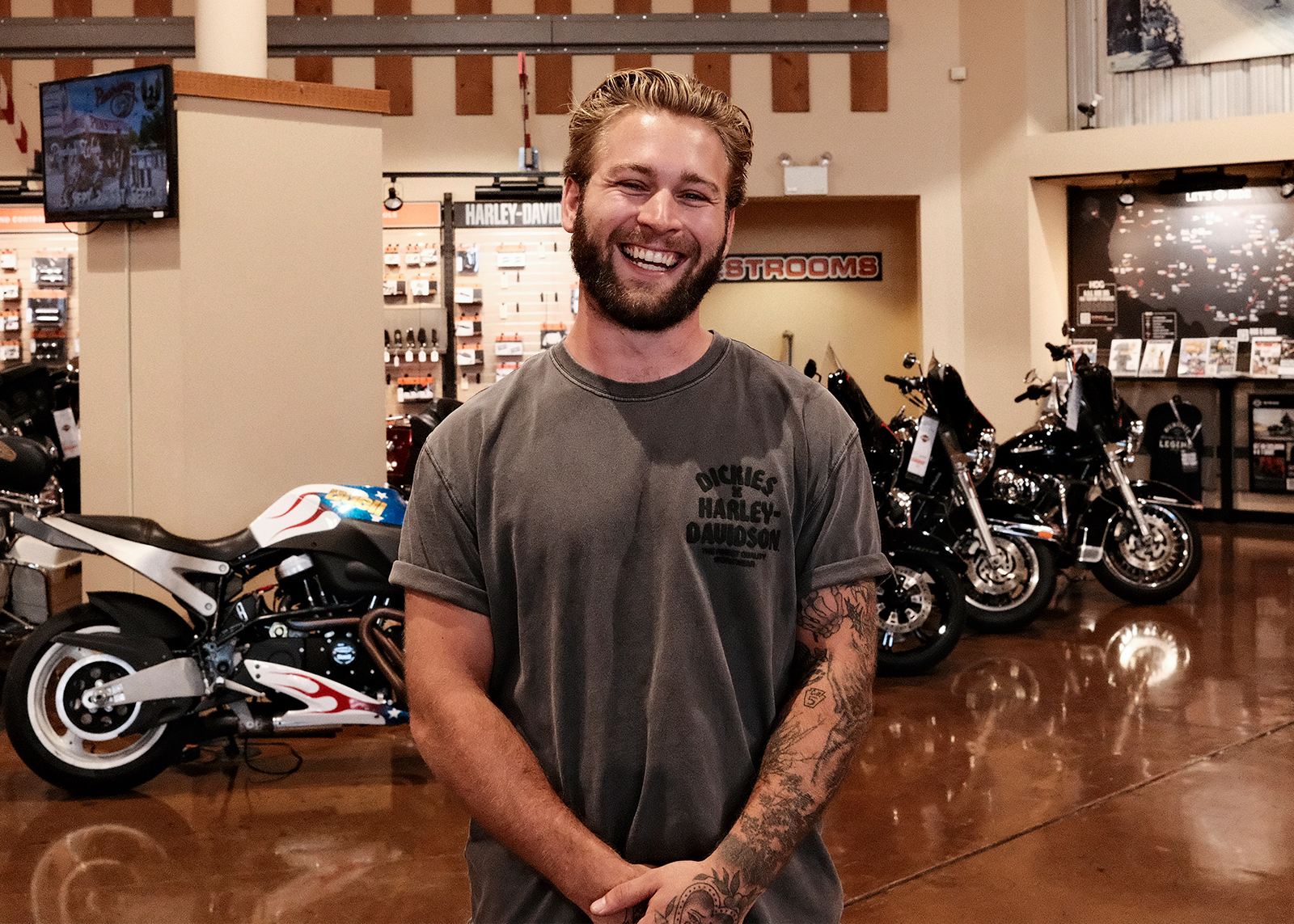 A young staff member at Classic Harley-Davidson smiles for the camera on the showroom floor.