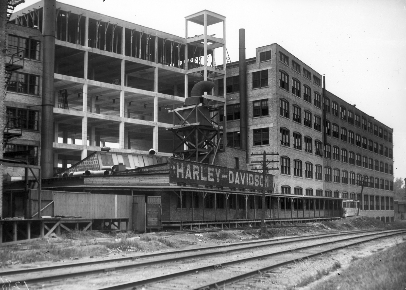 A large brick building with railroad tracks in front of it