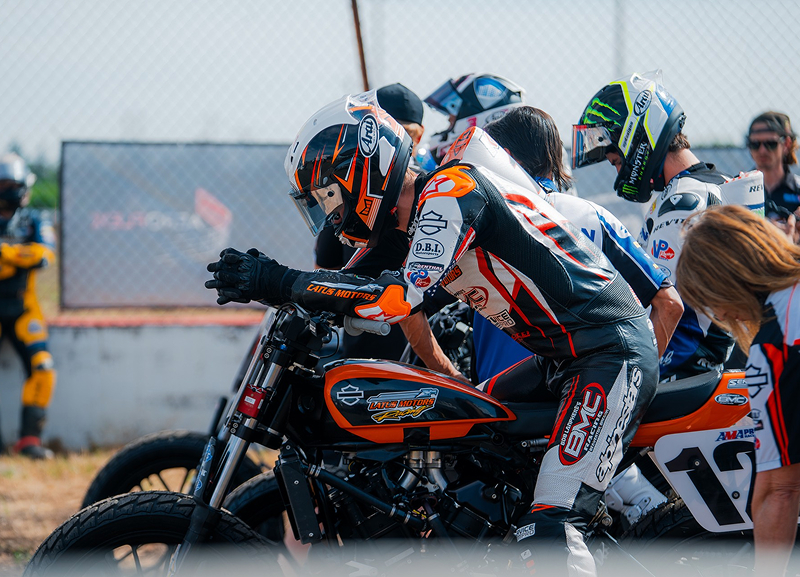 Kody Kopp concentrates during pit staging gripping bars as crew stands nearby preparing for start