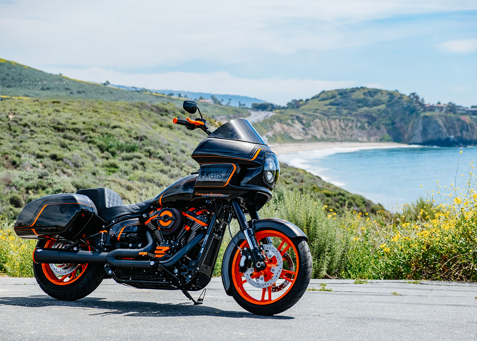 Laidlaw’s custom built motorcycle, The Laidlaw Coastglide, parked with the ocean and beach in the background.