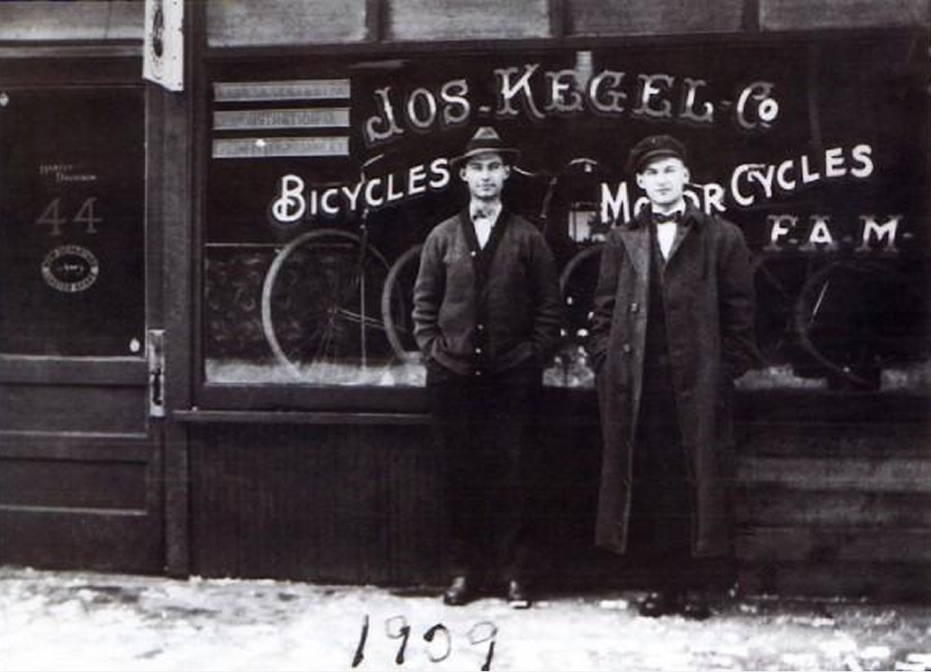 A Photo from 1909 of two men standing outside the original Joe Kegel’s Bicycles & Motorcycles