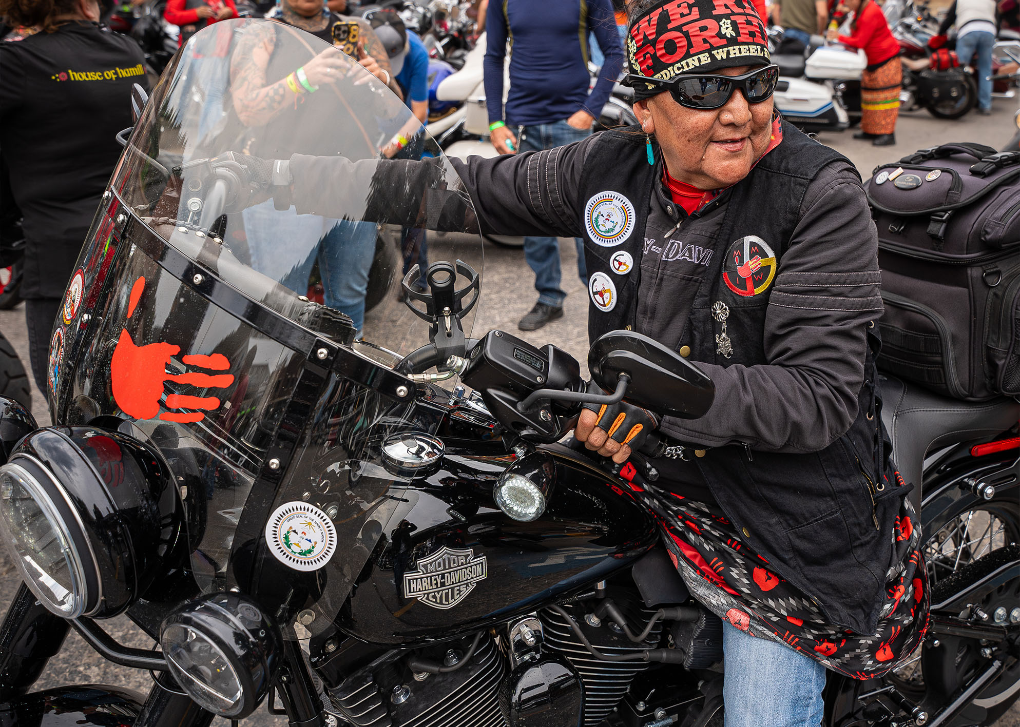 A Native American woman on her motorcycle pulls into a parking place