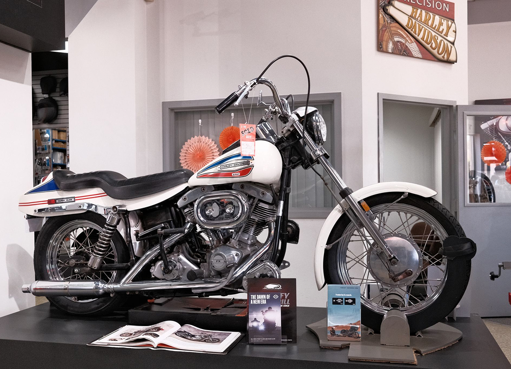 A 1971 FX Super Glide on display at Precision H-D with white paint and red and blue graphics