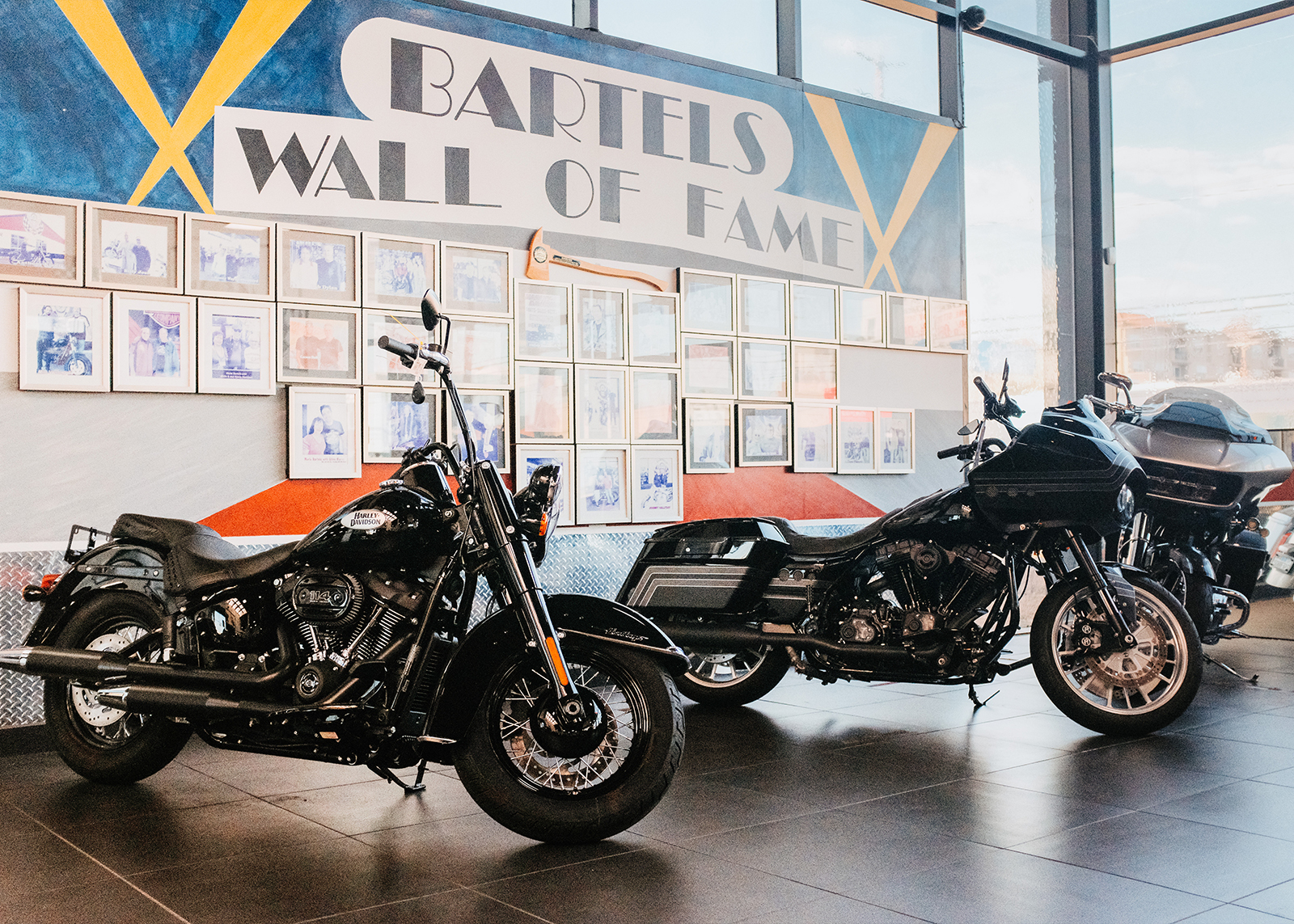 Motorcycles parked in front of the Bartel’s wall of fame, showing all the celebrities who have bought motorcycles from them over the years.