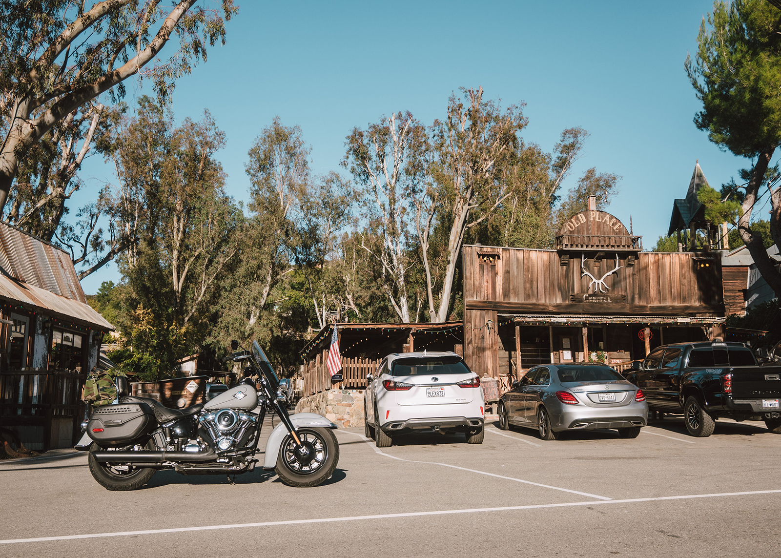 A Harley-Davidson Heritage Classic motorcycle parked in front of a rustic wooden building called the Old Place