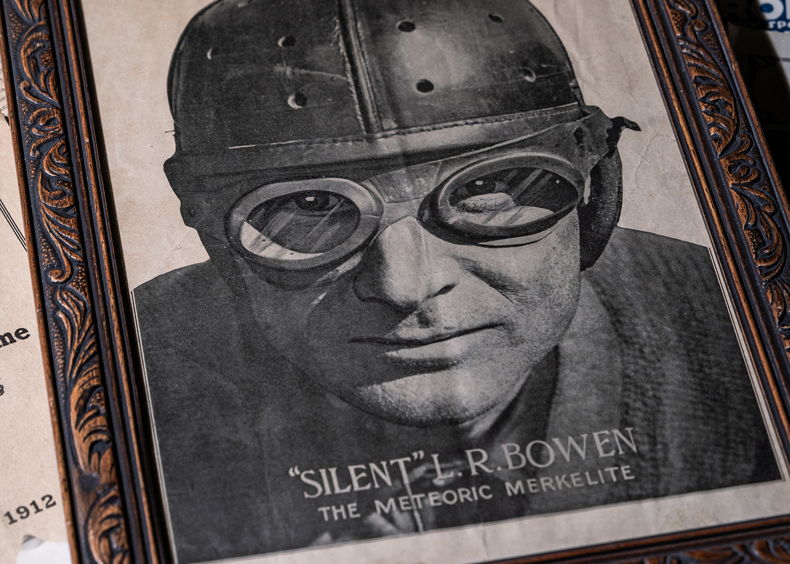 Vintage framed photo of racer Bowen wearing goggles and a helmet titled “Silent” L.R. Bowen, The Meteoric Merkelite