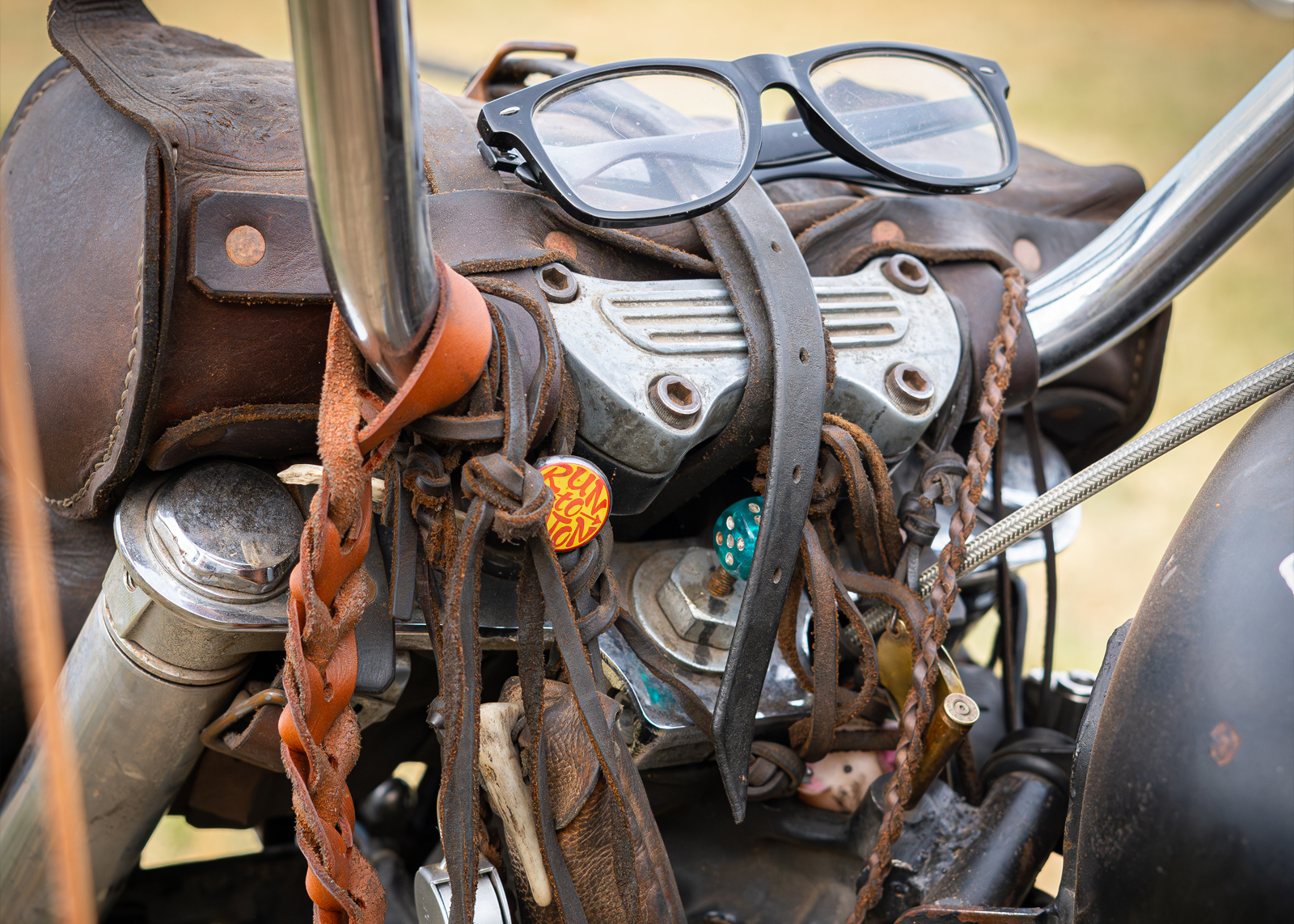 Glasses and leather straps and bag on the front of a bike