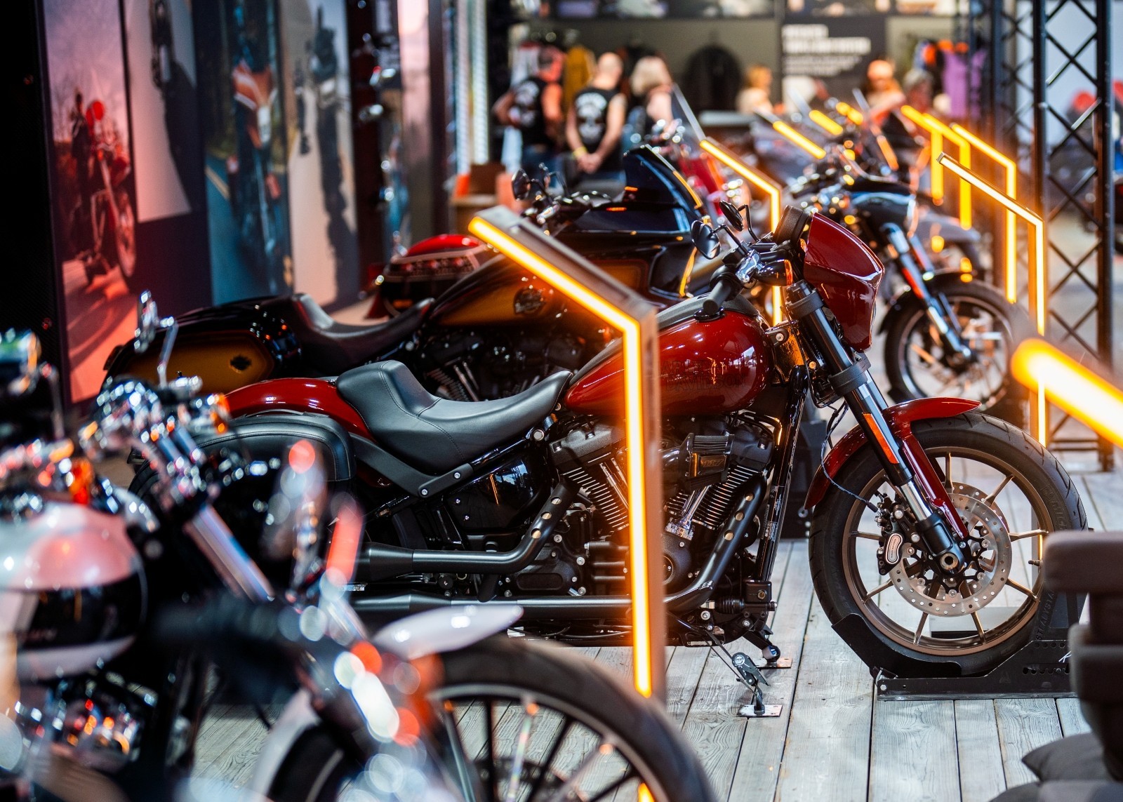 Row of custom motorcycles displayed indoors with warm lighting.