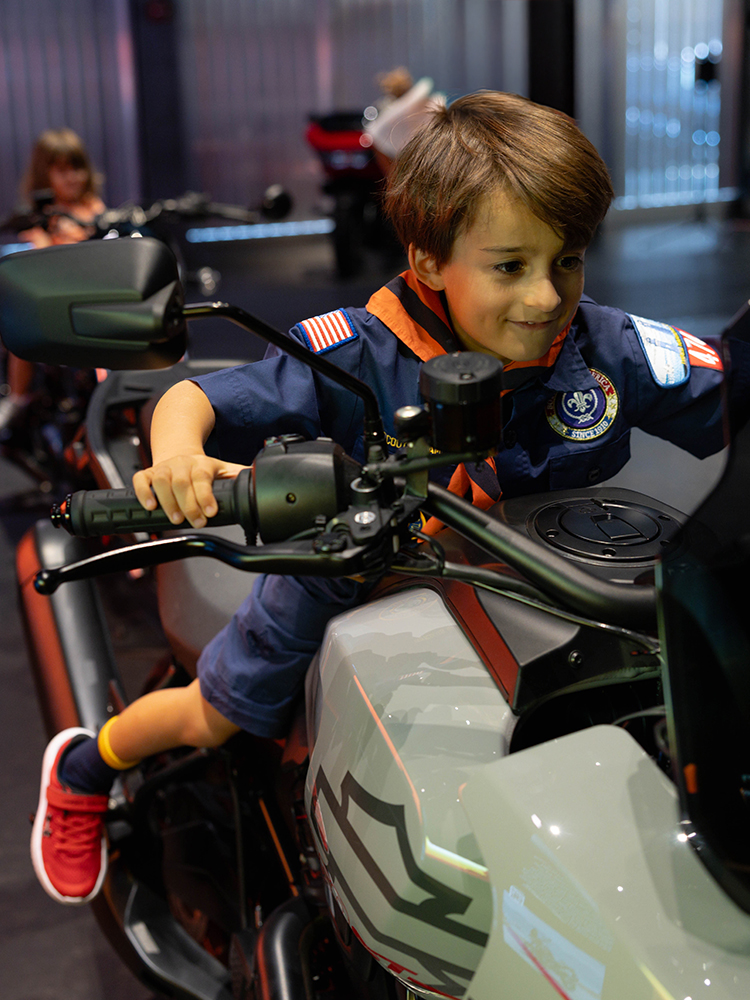 Child sitting on a motorcycle exhibit inside museum