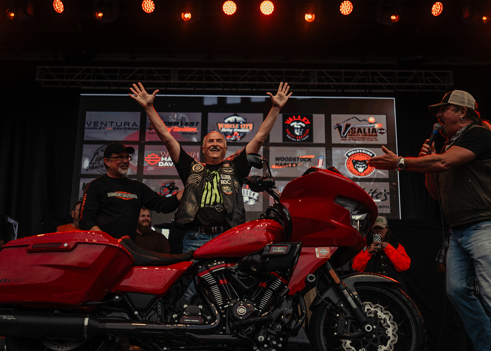 A man celebrates winning a motorcycle on stage
