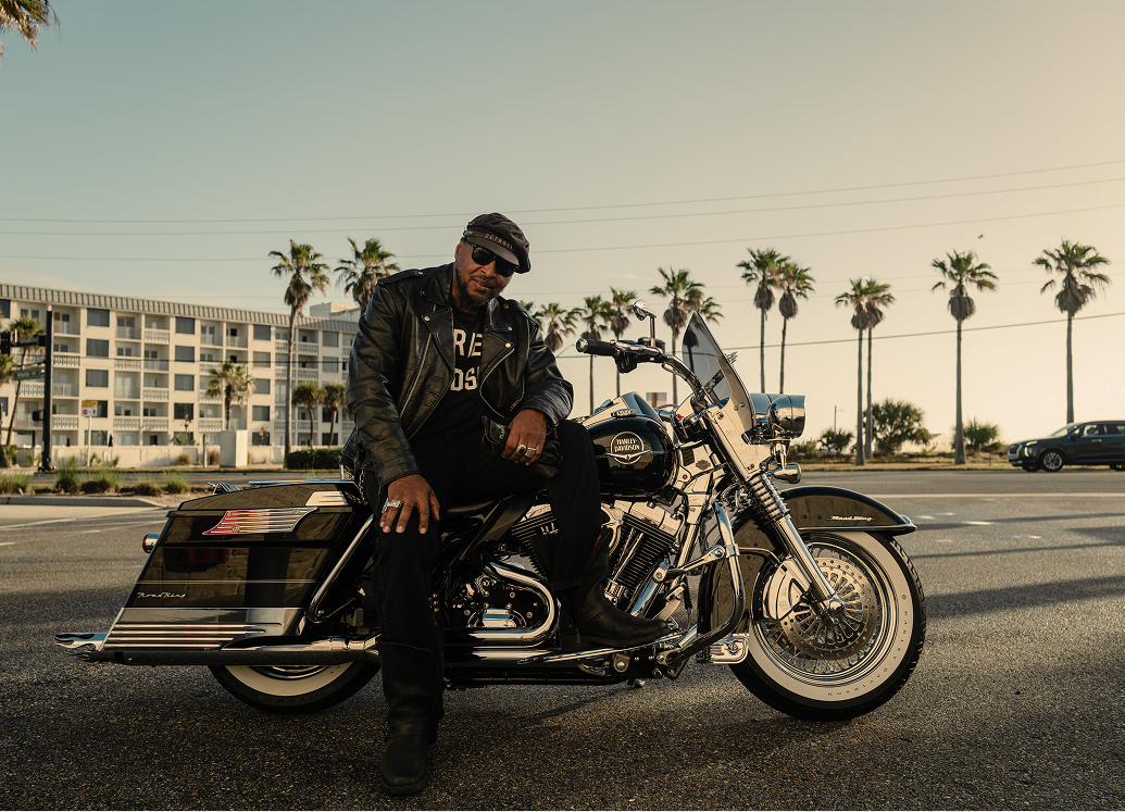 Detroit-based antique motorcycle collector, racer, and builder Randy "Detroit" Hayward poses with his motorcycle