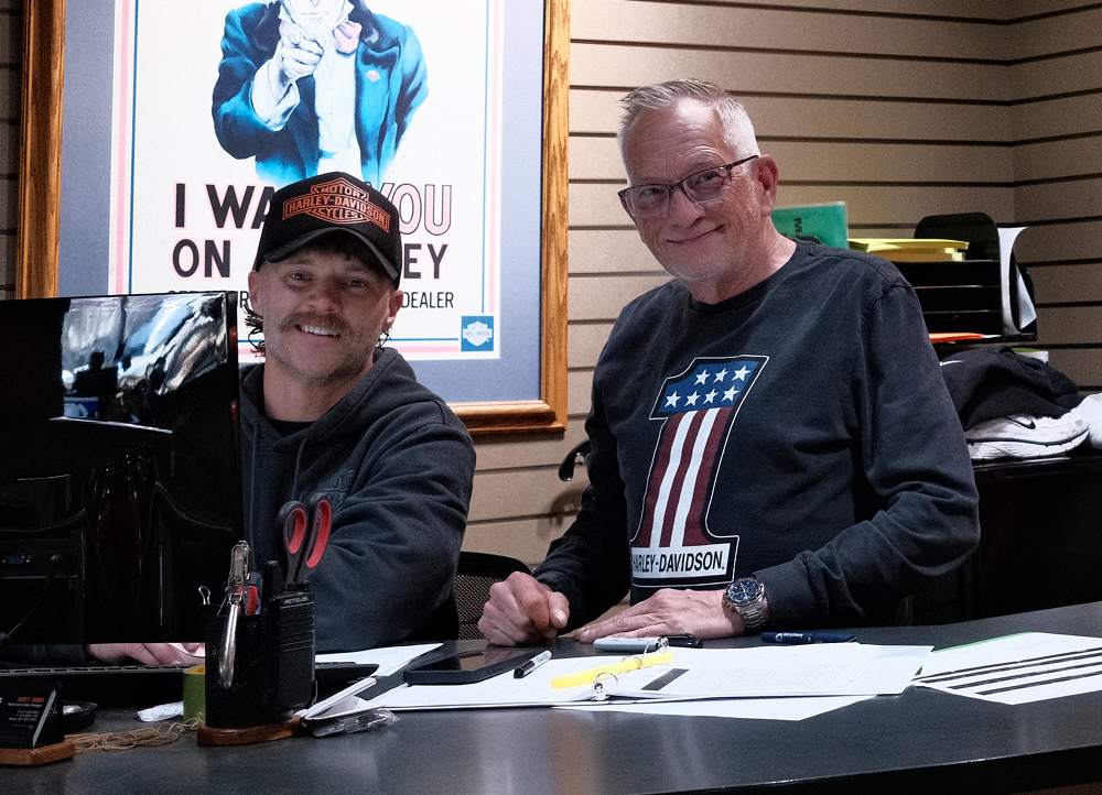 Two Bumpus Harley-Davidson dealership staff members working at a dealership counter
