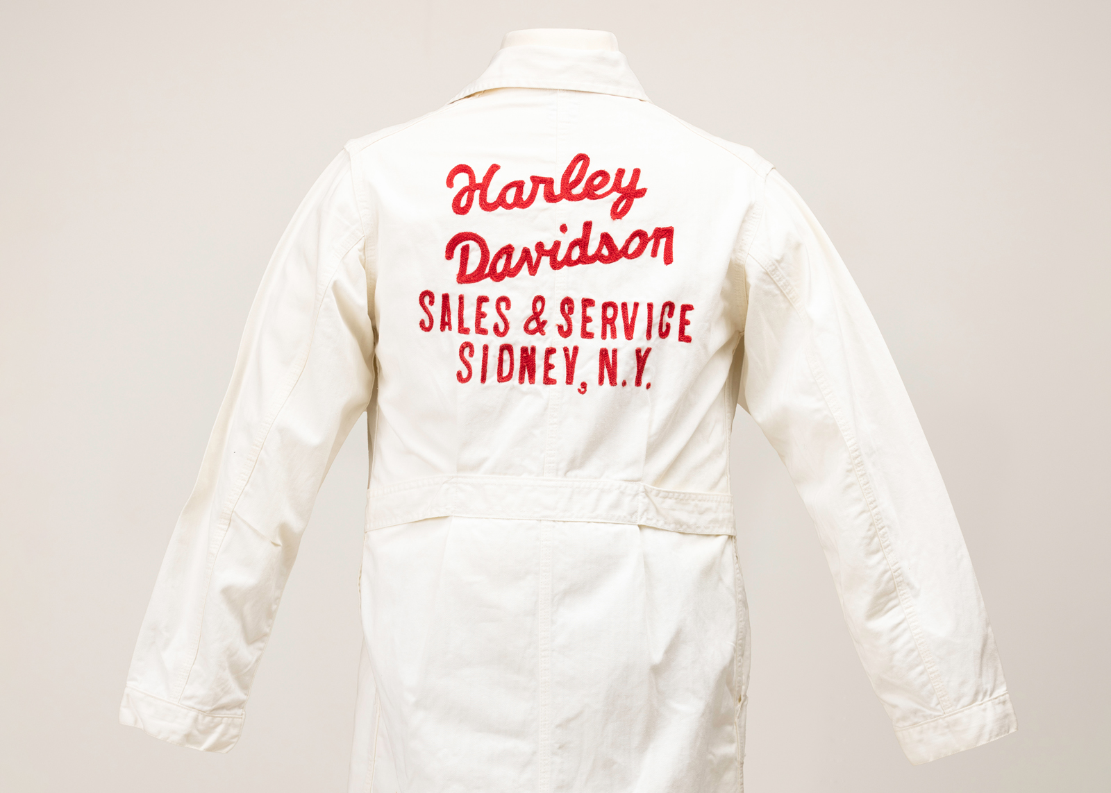The back of a white H-D jumpsuit with red lettering on a mannequin