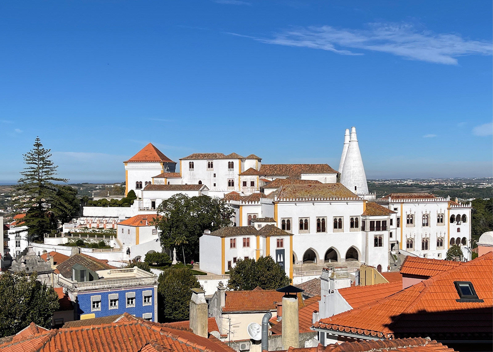 Hilltop complex in sintra with white towers overlooking colorful rooftops