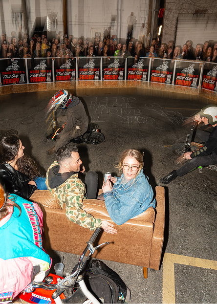 Participants sit on a couch in the middle of a circular course while mini bikes race around them