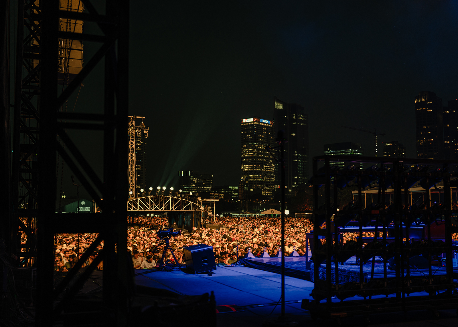 A concert audience with the Milwaukee skyline in the background at night