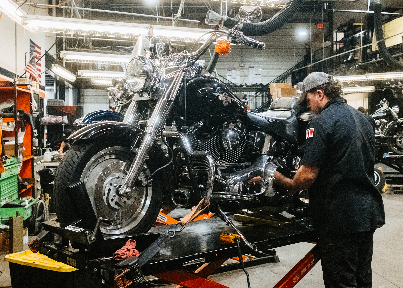 A Moonshine Harley-Davidson mechanic works on bike in the dealership’s garage.