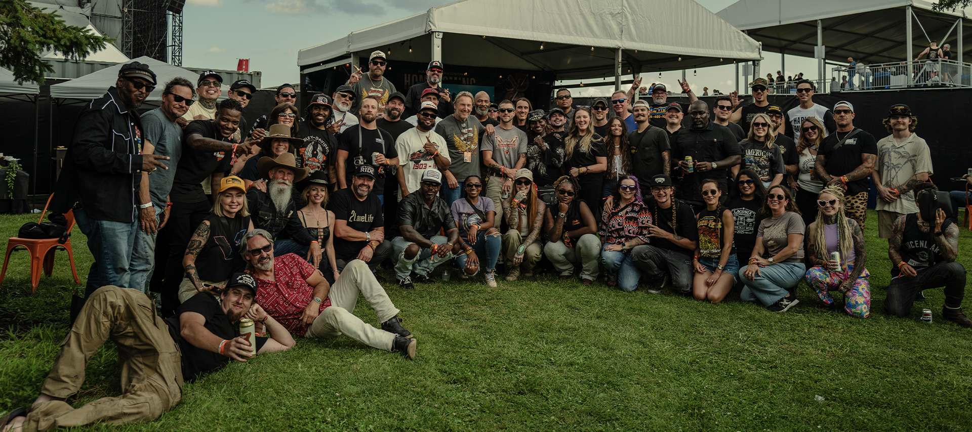 A large group of VIPs pose for a photo on the grass